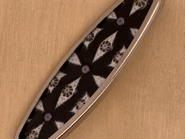 black and white enameled, glass and silver oval pin